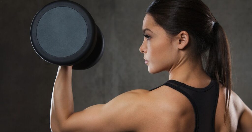 Woman lifting weights to build muscle and achieve a toned body